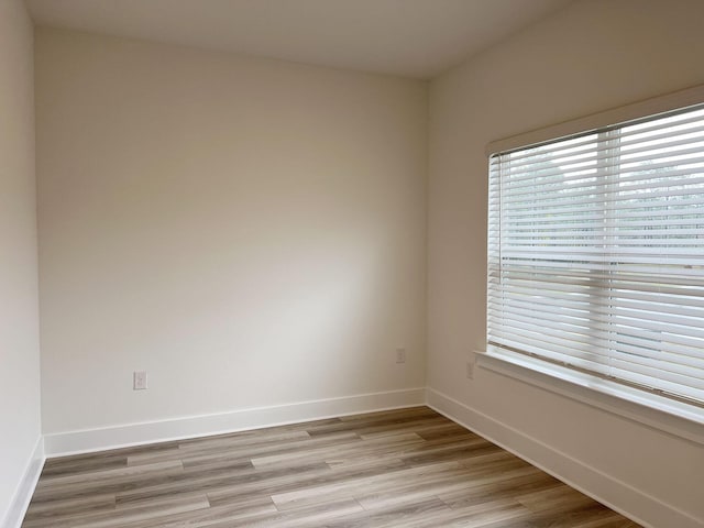 empty room featuring light wood-style floors and baseboards