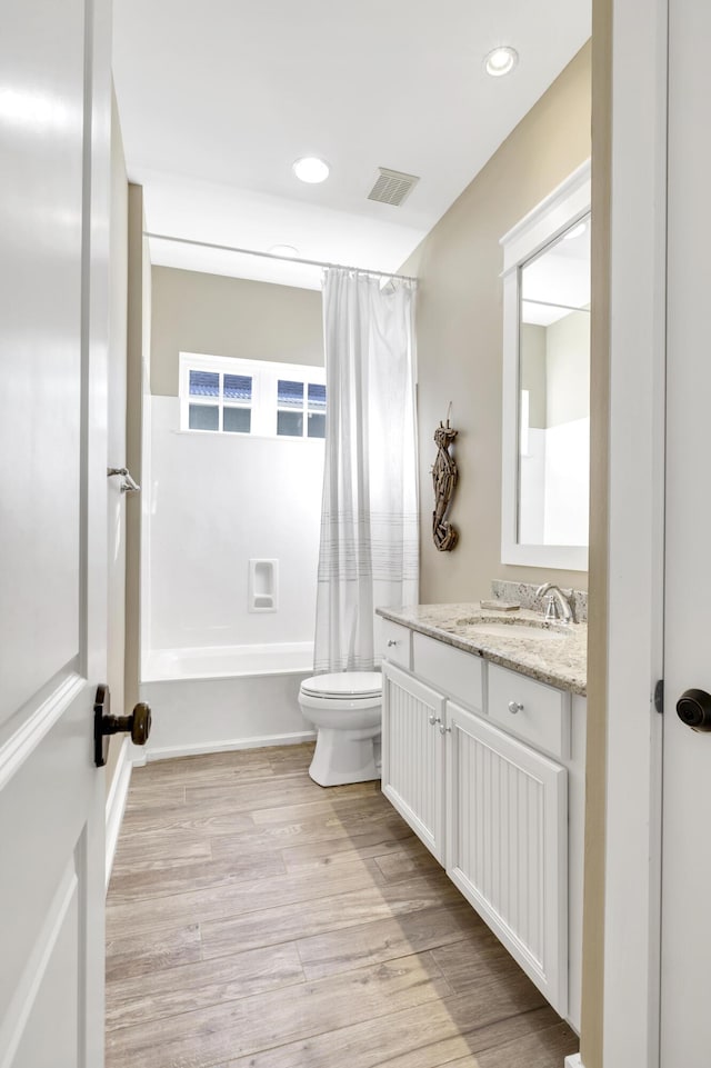 full bathroom with hardwood / wood-style flooring, vanity, toilet, and shower / bath combo with shower curtain