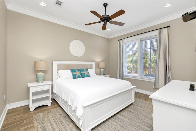 bedroom featuring hardwood / wood-style floors, ceiling fan, and crown molding