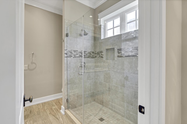 bathroom with crown molding, hardwood / wood-style floors, and a shower with shower door