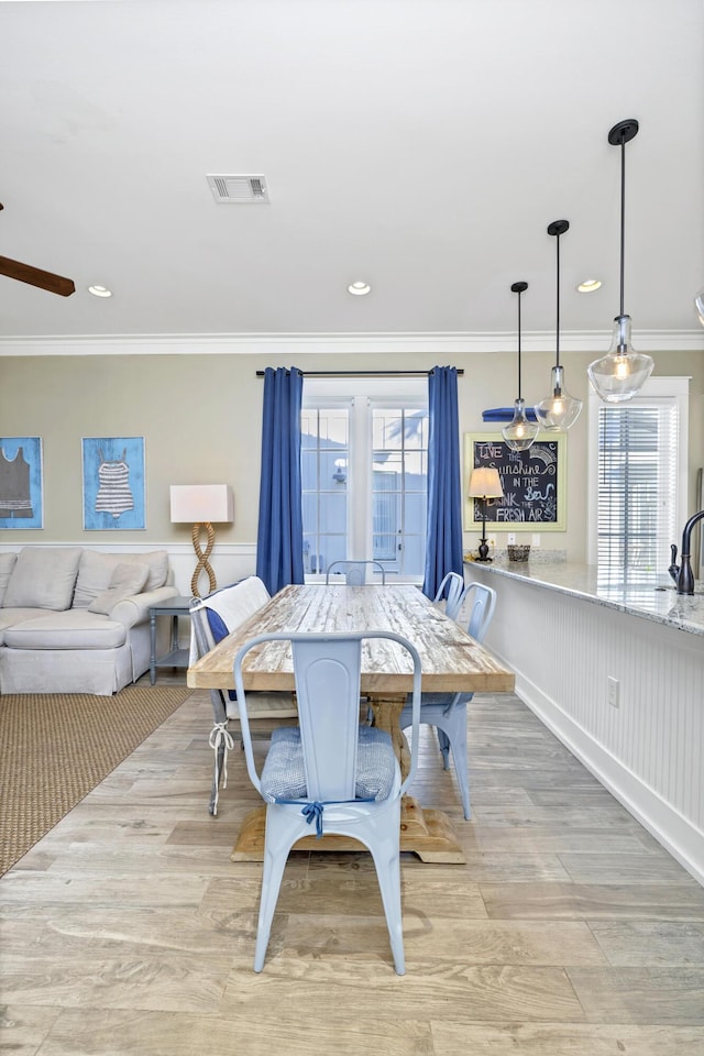 dining room with light hardwood / wood-style floors and ornamental molding