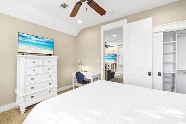 bedroom featuring ceiling fan, a closet, dark carpet, and vaulted ceiling