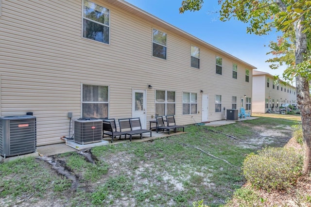 back of property with central air condition unit, a patio area, and outdoor lounge area