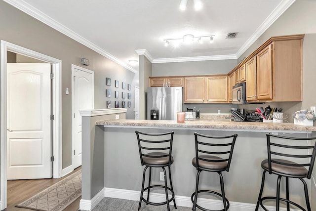 kitchen with kitchen peninsula, a kitchen breakfast bar, stainless steel fridge with ice dispenser, and ornamental molding