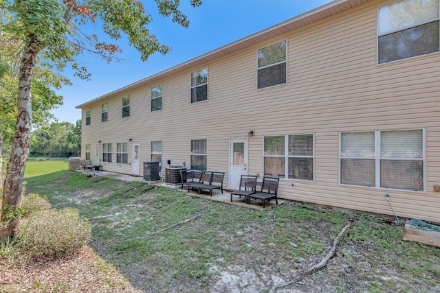 back of property with outdoor lounge area, a yard, a patio area, and central air condition unit