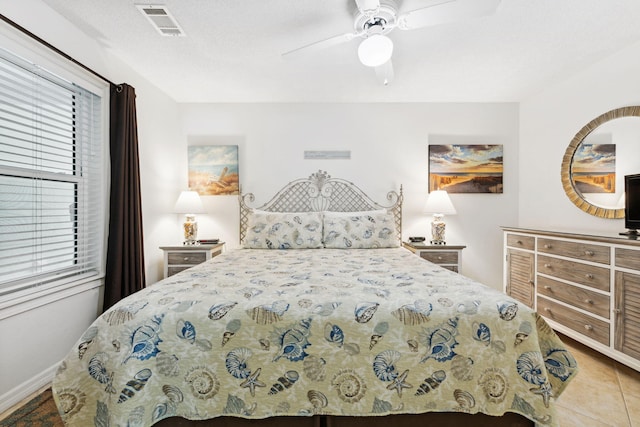 bedroom with ceiling fan and a textured ceiling