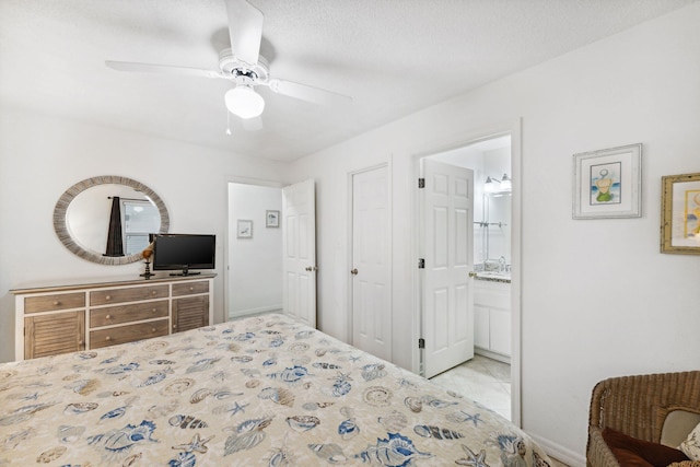 bedroom featuring connected bathroom, ceiling fan, and a textured ceiling