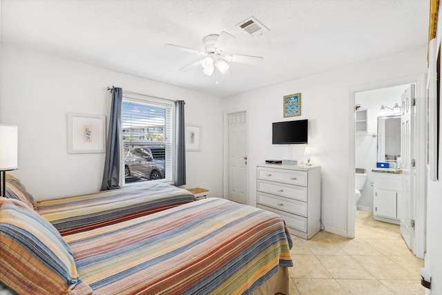 tiled bedroom featuring a textured ceiling, a closet, ensuite bath, and ceiling fan