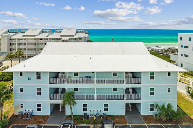 view of building exterior featuring a water view and cooling unit