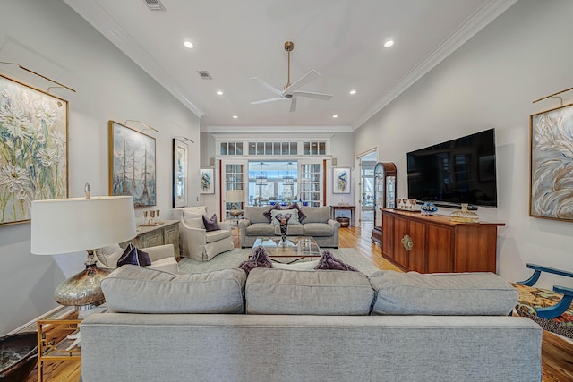 living room with ceiling fan, crown molding, and wood-type flooring