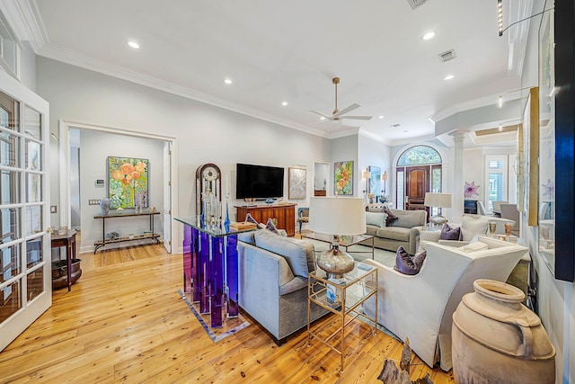 living room featuring ornate columns, ceiling fan, light hardwood / wood-style flooring, and ornamental molding