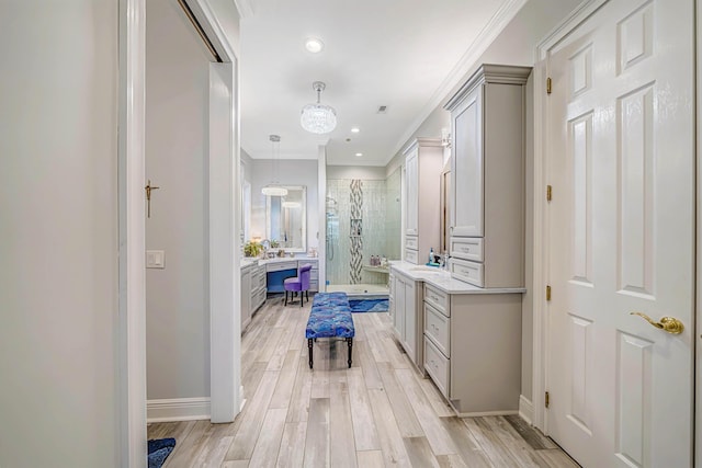 bathroom with walk in shower, hardwood / wood-style flooring, vanity, and ornamental molding