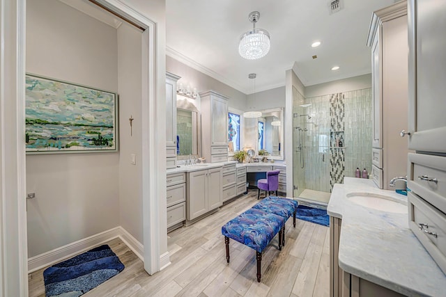 bathroom with a chandelier, hardwood / wood-style flooring, vanity, a shower with shower door, and ornamental molding