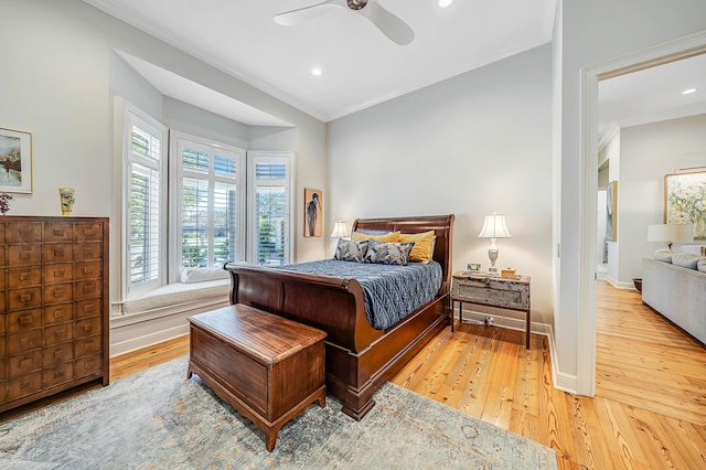 bedroom featuring ceiling fan, crown molding, and light hardwood / wood-style flooring