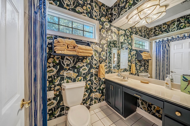 bathroom with toilet, tile patterned flooring, vanity, and an inviting chandelier