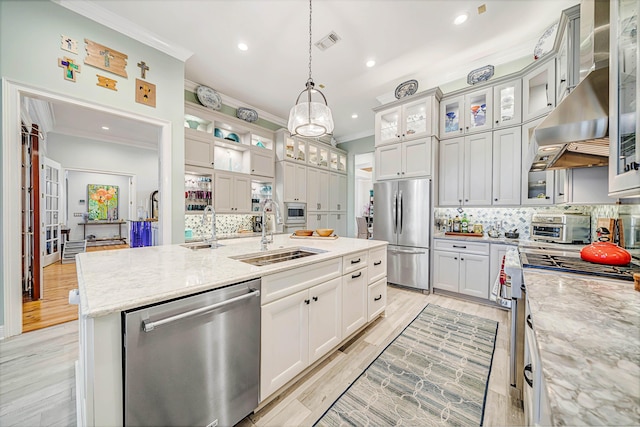 kitchen featuring sink, light stone counters, an island with sink, pendant lighting, and appliances with stainless steel finishes