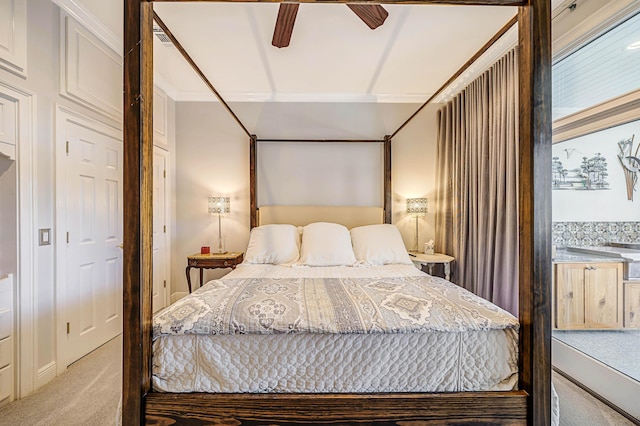 bedroom with ceiling fan, crown molding, and light carpet