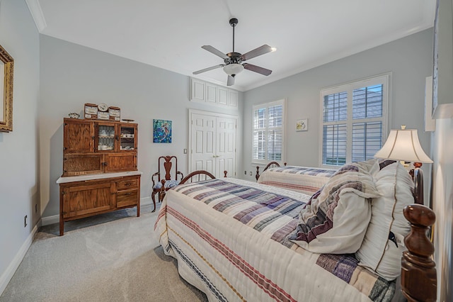 bedroom featuring a closet, light colored carpet, ceiling fan, and crown molding