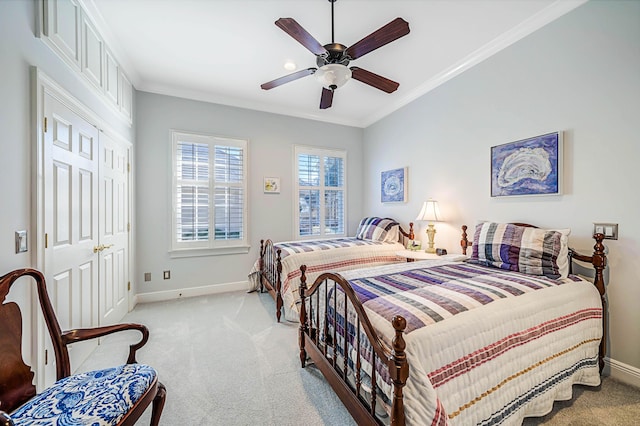 carpeted bedroom featuring ceiling fan and crown molding