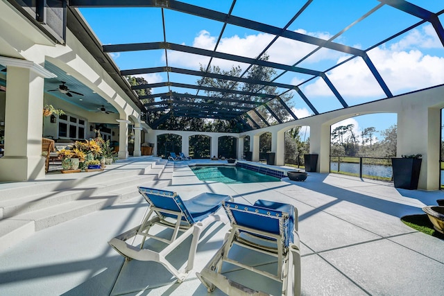 view of swimming pool featuring glass enclosure, ceiling fan, and a patio