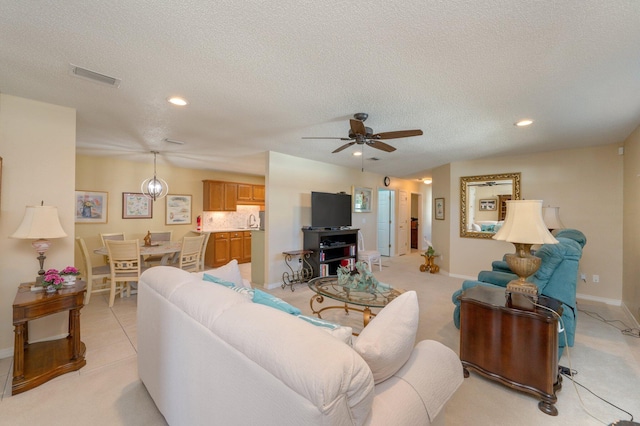 living room featuring ceiling fan and a textured ceiling