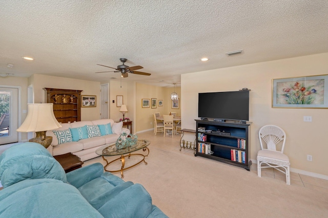 living room featuring a textured ceiling, light colored carpet, and ceiling fan