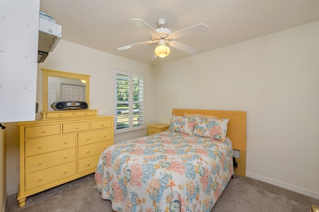 bedroom featuring a textured ceiling, dark carpet, and ceiling fan