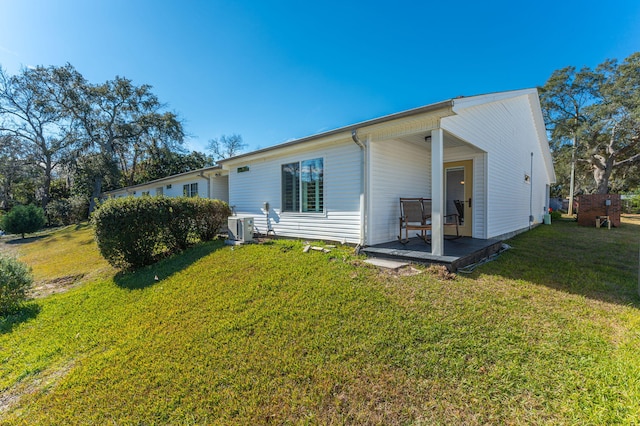 rear view of house with a lawn and central AC