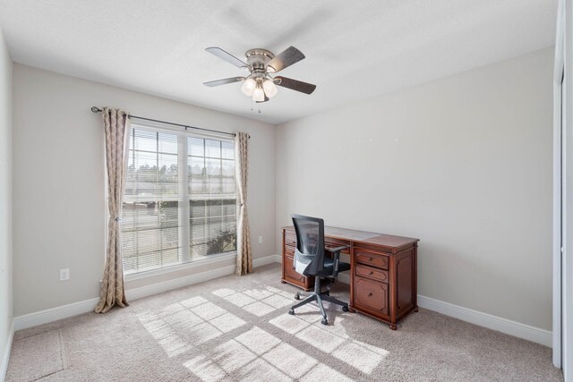 office space featuring ceiling fan and light carpet