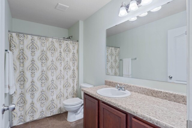 bathroom featuring tile patterned flooring, vanity, and toilet