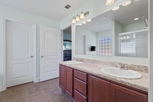 bathroom featuring tile patterned floors, a shower with door, and vanity