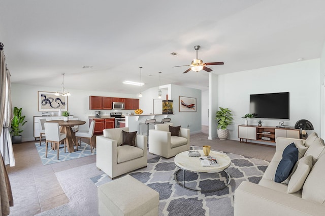 living room with lofted ceiling, light tile patterned floors, and ceiling fan with notable chandelier