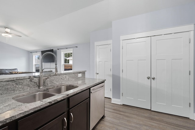 kitchen featuring light stone countertops, dishwasher, sink, light hardwood / wood-style flooring, and dark brown cabinets