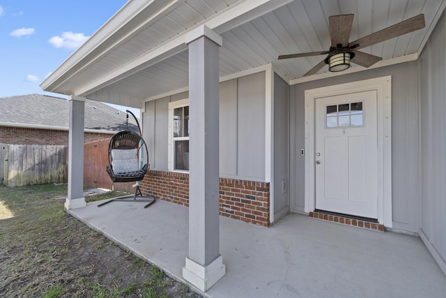 view of exterior entry with ceiling fan and a patio