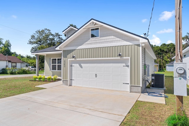 view of front facade with a garage, cooling unit, and a front lawn