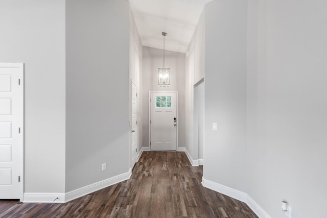 entryway featuring vaulted ceiling, a notable chandelier, and dark hardwood / wood-style flooring