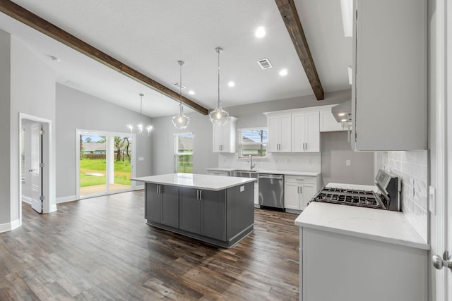 kitchen with lofted ceiling with beams, stainless steel dishwasher, white cabinets, and a kitchen island