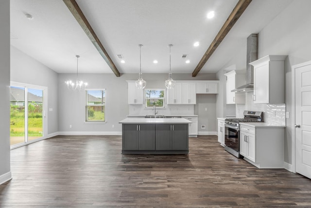 kitchen with pendant lighting, a center island, tasteful backsplash, white cabinets, and stainless steel range with gas cooktop