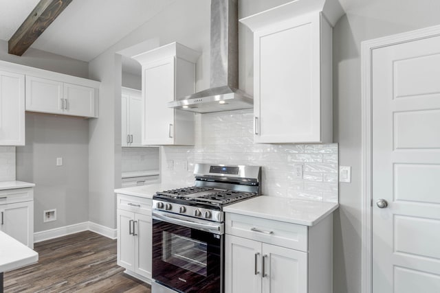 kitchen with backsplash, white cabinets, stainless steel range with gas stovetop, and wall chimney range hood