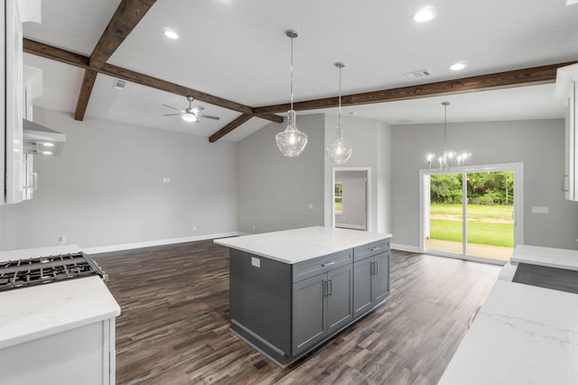 kitchen with gray cabinetry, a center island, light stone counters, dark hardwood / wood-style flooring, and decorative light fixtures