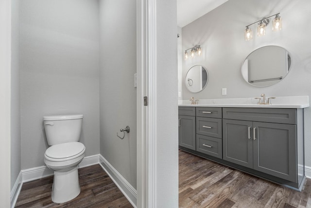 bathroom with wood-type flooring, toilet, and vanity