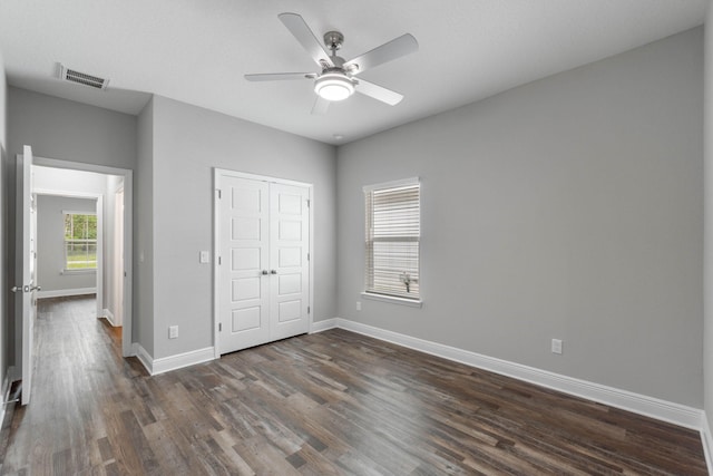 unfurnished bedroom featuring ceiling fan, dark hardwood / wood-style flooring, and a closet