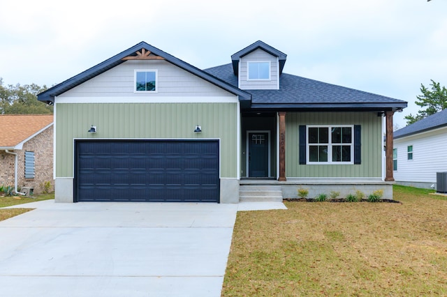 view of front of property featuring a garage, driveway, roof with shingles, central AC, and a front yard