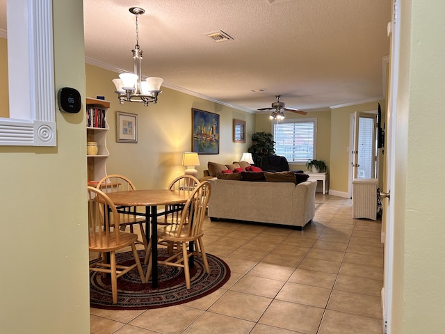 dining area featuring a textured ceiling, ceiling fan with notable chandelier, light tile patterned floors, and crown molding