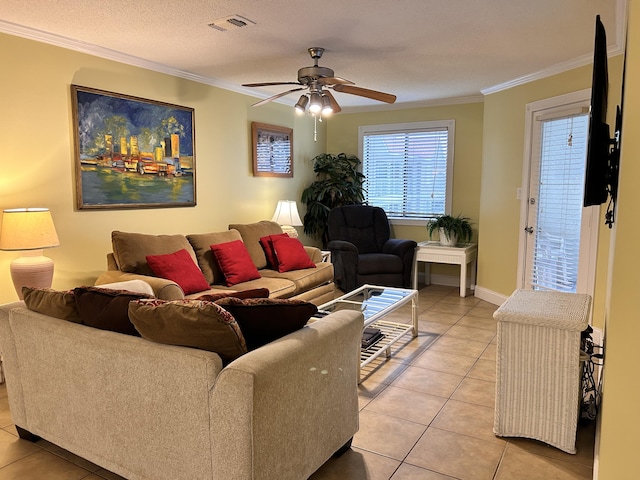 living room featuring ceiling fan, light tile patterned flooring, ornamental molding, and a textured ceiling