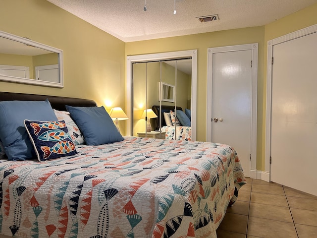 tiled bedroom with a textured ceiling