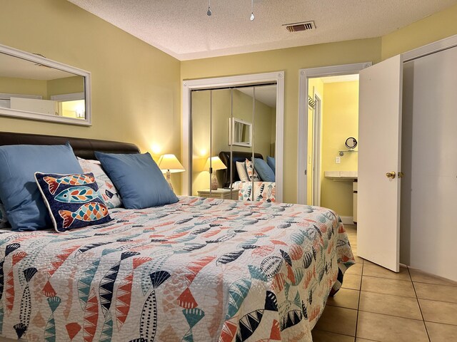 tiled bedroom featuring a textured ceiling