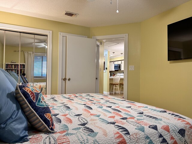 bedroom with a textured ceiling and a closet