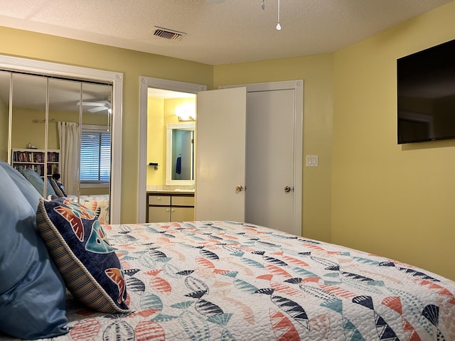 bedroom featuring a textured ceiling and connected bathroom