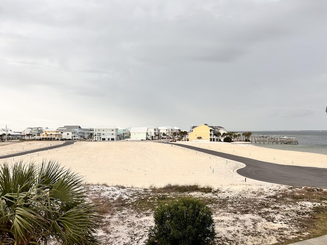 view of yard with a water view and a view of the beach